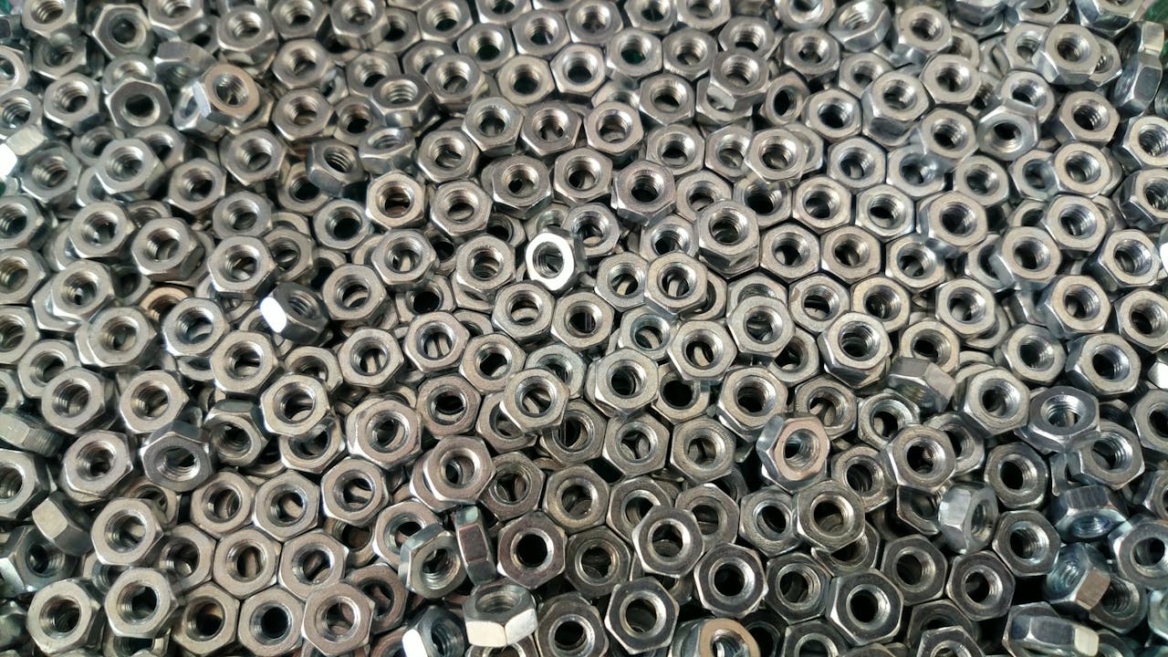 heros-img Detail of numerous stainless steel nuts creating an industrial texture.